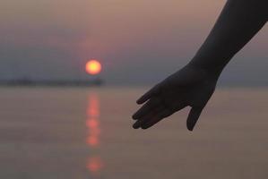 hand bij zonsondergang foto