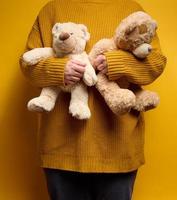 vrouw in oranje gebreid trui knuffels schattig bruin teddy beer foto