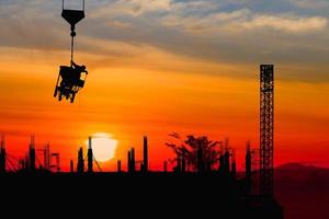 silhouet bouw arbeider Aan kraan haak Aan zonsondergang zonsopgang tijd achtergrond en kopiëren ruimte toevoegen tekst foto