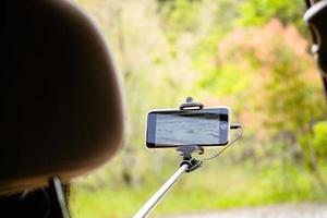 toerist nemen panoramisch afbeelding Vermelding video van zomer natuur landschap Aan weg reis buitenshuis in zomer. reizen en avontuur. reiziger duurt video van landschap Aan smartphone foto