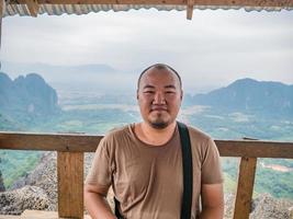 portret foto van dik toerist met mooi visie Aan de top van pha ngeun in vangvieng stad laos.vangvieng stad de beroemd vakantie bestemming stad- in laos.