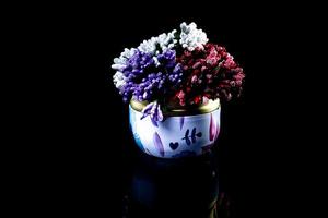 metalen vaas met wit rood blauw bloemen . met reflectie, zwart achtergrond geïsoleerd, foto