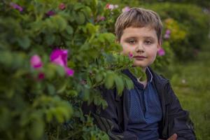 portret van een kind, een jongen tegen de achtergrond van planten in een open lucht park. kinderen, reizen. levensstijl in de stad. centrum, straten. foto