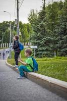 portret van een kind, een jongen tegen de backdrop van stedelijk landschappen van wolkenkrabbers en hoogbouw gebouwen in de Open lucht. kinderen, reizen. levensstijl in de stad. centrum, straten. foto