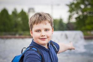 portret van een kind, een jongen tegen de backdrop van stedelijk landschappen van wolkenkrabbers en hoogbouw gebouwen in de Open lucht. kinderen, reizen. levensstijl in de stad. centrum, straten. foto