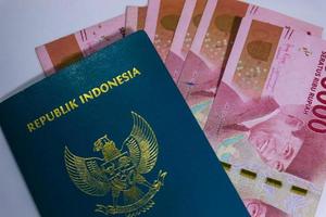 Indonesisch groen paspoort met een verzameling van honderd duizend roepia net zo de achtergrond. foto