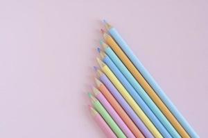 pastel gekleurde potloden, top visie Aan roze achtergrond, illustratie concept, onderwijs en terug naar school- foto