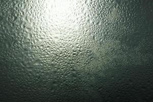 regendruppels op een raam in het donker foto