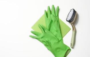 groen tapijt, rubber handschoenen voor schoonmaak, borstels Aan een wit achtergrond, vlak leggen. foto