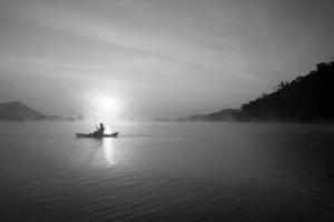 Dames Aan kajak rijen in de reservoir gedurende de zonsopkomst, harak Woud park huai naam Mens reservoir loei Thailand 21 jan 2023 foto