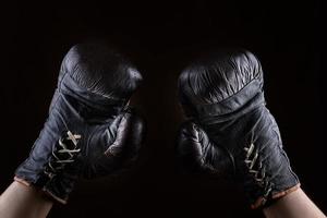 verheven omhoog armen van een atleet gekleed in leer bruin boksen handschoenen foto