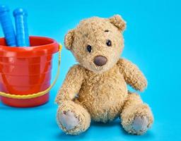 bruin teddy beer en baby plastic rood emmer foto