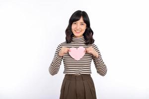 mooi jong Aziatisch vrouw Holding een papier hart terwijl staand tegen wit achtergrond. mooi jong Aziatisch vrouw met papier hart. foto