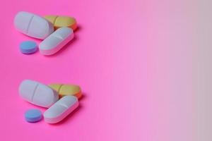 kleurrijk drugs. pillen en capsules Aan een roze achtergrond. kopiëren ruimte. foto