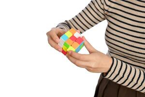 vrouw handen Holding een rubik kubus staand Aan wit achtergrond foto