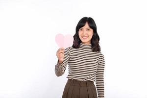 mooi jong Aziatisch vrouw Holding een papier hart terwijl staand tegen wit achtergrond. mooi jong Aziatisch vrouw met papier hart. foto