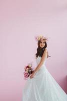 jong bruid in wit jurk met bloem krans Aan haar hoofd poseren in de studio foto