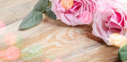 bloemen banier voor romantisch vakantie met vers roze rozen Aan hout bord kleur bokeh lichten kopiëren ruimte foto