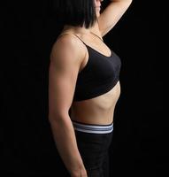 lichaam van een meisje van atletisch uiterlijk in een zwart beha en leggings foto