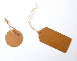 divers bruin papier tags met touwen Aan wit achtergrond foto