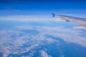 bovenaanzicht blauwe hemel met vleugel van vliegtuig foto