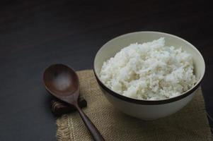 Thaise rijst in kom met houten lepel op lijst foto