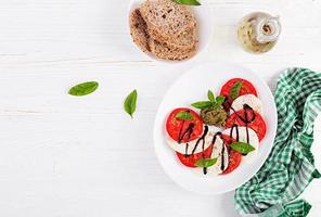 traditioneel Italiaans caprese salade met Mozzarella, tomaat, basilicum en balsamico azijn. top visie, overhead foto