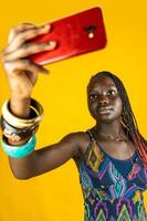 jong Afrikaanse Amerikaans vrouw met traditioneel jurk duurt een selfie foto
