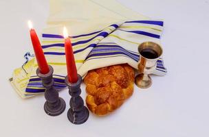 tafel reeks voor sjabbat met verlicht kaarsen, challah brood en wijn. foto