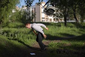 een gelukkig schooljongen gooit omhoog zijn school- rugzak en verheugt zich Bij de begin van de vakantie. de einde van de school- jaar en de begin van de vakantie. foto