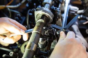 mercedes diesel motor reparatie. handen met een monteur repareren mercedes onderdelen. klep opruiming aanpassing. foto