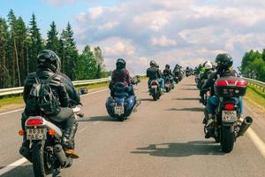 groep van motorrijders ritten Aan asfalt land weg Aan zomer zonnig dag. optocht van motorfietsen. foto