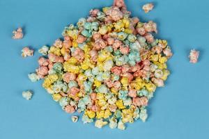 veelkleurig popcorn is verspreide Aan een blauw achtergrond. kleurrijk mooi zoet nagerecht. foto