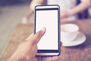 dichtbij omhoog van handen Mens gebruik makend van telefoon in koffie winkel met diepte van veld- foto