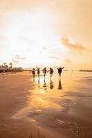 een groep van Aziatisch tieners rennen met gelukkig uitdrukkingen Aan vakantie met hun vrienden dronken Aan de strand foto