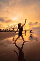 een groep van Aziatisch Dames dansen samen en vol van vreugde Aan de strand foto