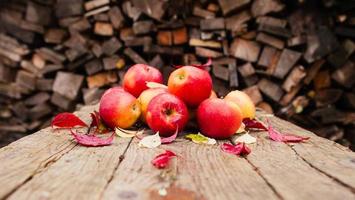 stilleven met verschillende rode appels liggend op een oude houten tafel foto