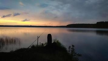 zonsondergang lucht over- meer landschap, natuur achtergrond met visvangst hengel silhouet foto