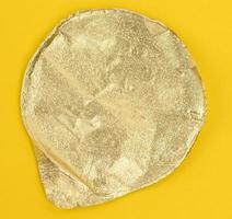 ronde gouden aluminium dun deksel voor plastic yoghurt potten Aan een geel achtergrond foto