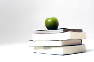 stapel boeken met groene appel witte achtergrond foto