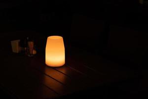 ingetogen licht van een lamp Aan een tafel Bij nacht in een cafe, kopiëren ruimte foto