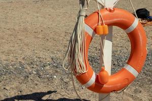 oranje reddingsboei Aan een zanderig strand. veilig zomer vakantie foto