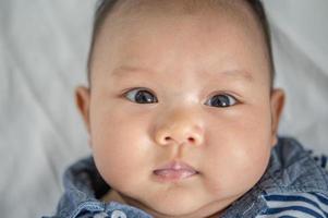 een pasgeboren baby die zijn ogen opent en vooruit kijkt foto