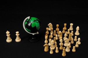 plastic wereldbol met schaak stukken foto
