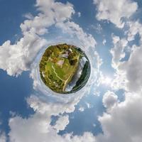 klein planeet in lucht met wolken met uitzicht oud dorp, stedelijk ontwikkeling, historisch gebouwen en kruispunt. transformatie van bolvormig 360 panorama in abstract antenne visie. foto