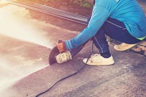 dichtbij omhoog hand- Mens snijdend beton verdieping met machine. foto