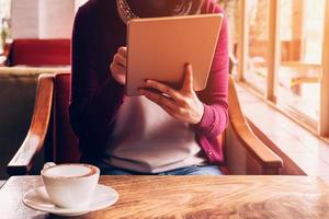 vrouw hand- gebruik makend van tablet in koffie winkel cafe met wijnoogst afgezwakt. foto