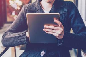 vrouw gebruik makend van tablet in koffie winkel met wijnoogst toon. foto