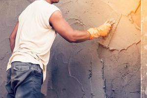 Mens stukadoor beton werken Bij muur van huis bouw gebouw. foto