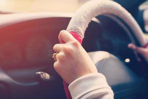 dichtbij omhoog hand- vrouw het rijden auto Aan weg met wijnoogst toon. foto